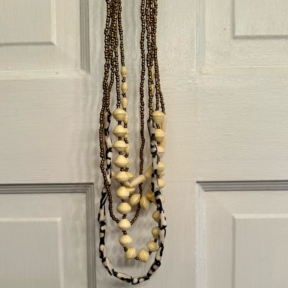 Noonday handmade beaded necklace, color: gold, cream, & black